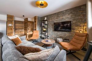 salon z kanapą i ścianą z cegły w obiekcie Appartement neuf et spacieux au cœur du village avec sauna w mieście Saint-Sorlin-dʼArves