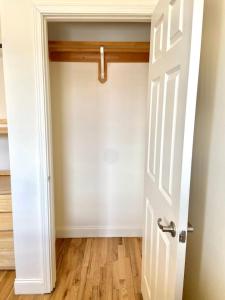 an empty room with a white door and wooden floors at 221-Modern 2B 2B on Hobokens Main Street in Hoboken +5 photos