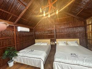 a room with two beds in a straw hut at FARMSTAY HOÀNG HÔN in Xóm Mũi