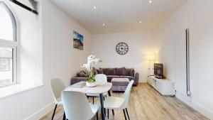 sala de estar con mesa y sofá en Spacious three bedroom apartment with Valley views en Abertillery