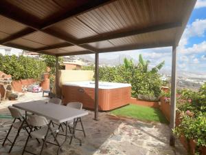 a patio with a hot tub and a table and chairs at 2 bedrooms house with sea view jacuzzi and enclosed garden at Adeje 1 km away from the beach in Adeje
