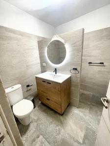 a bathroom with a toilet and a sink and a shower at 2 bedrooms house with sea view jacuzzi and enclosed garden at Adeje 1 km away from the beach in Adeje