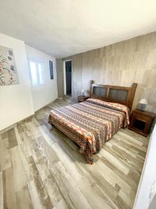 a bedroom with a bed and a wooden floor at 2 bedrooms house with sea view jacuzzi and enclosed garden at Adeje 1 km away from the beach in Adeje