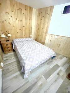 a bedroom with a bed and a wooden wall at 2 bedrooms house with sea view jacuzzi and enclosed garden at Adeje 1 km away from the beach in Adeje