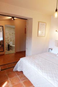 Ayguetinte的住宿－Chambre Aramis，一间带白色床的卧室和一间浴室