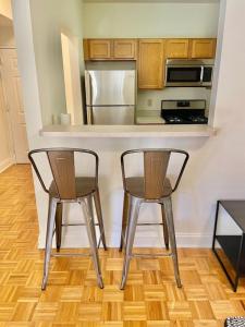 Duas cadeiras sentadas num balcão de cozinha com um micro-ondas em 103-2 Bed Modern Apt in the Heart of Hoboken em Hoboken