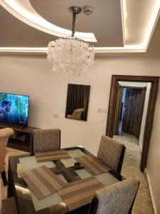 a dining room with a glass table and a chandelier at Le Masik Hotel in Ilora