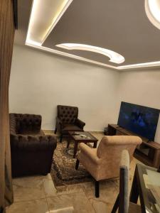 Le Masik Hotel في Ilora: غرفة معيشة مع كنب وتلفزيون بشاشة مسطحة