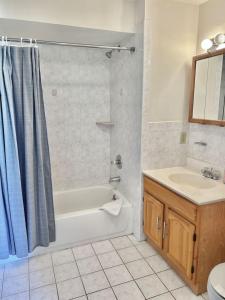 ein Badezimmer mit einer Badewanne und einem Waschbecken in der Unterkunft 0123-Spacious Apartment in the Heart of Hoboken in Hoboken