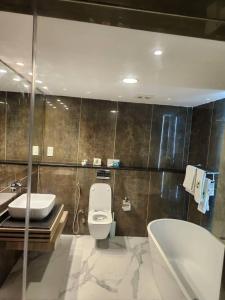 Le Masik Hotel في Ilora: حمام مع مرحاض ومغسلة وحوض استحمام