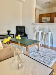 a living room with a glass vase with flowers on a table at 124-2 Bedroom 2 Bath Apt in Heart of Hoboken in Hoboken