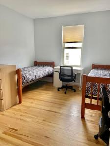 um quarto com 2 camas, uma secretária e uma cadeira em 212-Two Bedroom Apt.with Patio and Free Laundry em Hoboken