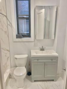 ein weißes Bad mit einem WC und einem Waschbecken in der Unterkunft 301-Two Bedroom Apartment in Hoboken in Hoboken