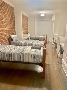 Zimmer mit 3 Betten und Ziegelwand in der Unterkunft 301-Two Bedroom Apartment in Hoboken in Hoboken