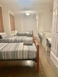 3 Betten in einem Zimmer mit Tisch und Stühlen in der Unterkunft 301-Two Bedroom Apartment in Hoboken in Hoboken