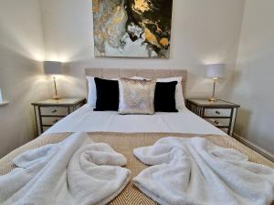 ein Schlafzimmer mit einem Bett mit weißen Decken darauf in der Unterkunft Chic Luxury Serviced Apartment next to City Centre with Free Parking - Contractors & Relocators in Coventry