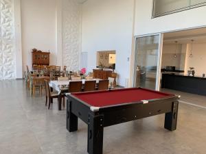 a pool table in a room with tables and chairs at Hospedaria Colinas in Indaiatuba