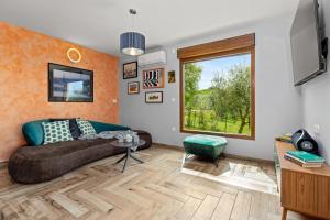 ein Wohnzimmer mit einem Sofa und einem Fenster in der Unterkunft Villa Rok in beautiful olive oasis, 2BD, pool, WIFI in Puntera