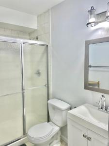 uma casa de banho com um chuveiro, um WC e um lavatório. em 205-Bright and Airy 2Bed 2 Bath Apartment in Hoboken em Hoboken