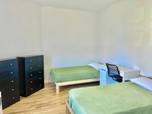 um quarto com 3 camas, uma secretária e uma cómoda em 205-Bright and Airy 2Bed 2 Bath Apartment in Hoboken em Hoboken