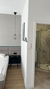 - une chambre avec un lit et une douche en verre dans l'établissement Kamienica Łódzka, à Łódź