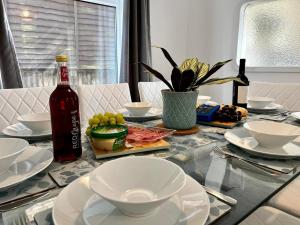 Spacious Family home in great location in Cardiff في كارديف: طاولة زجاجية مع صحون وزجاجة من الكحول