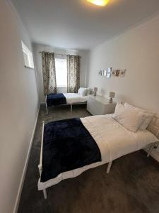 Spacious Family home in great location in Cardiff في كارديف: غرفة نوم بسرير كبير وأريكة
