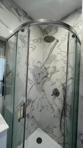 a shower with a glass door in a bathroom at Kamienica Łódzka in Łódź