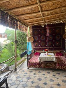 uma cama num alpendre de uma casa em Sohil boyi em Fergana