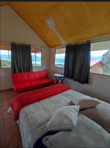 una camera da letto con un letto grande e un divano rosso di El Mirador de Juan a Guasca