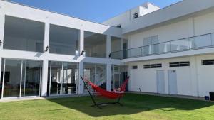 a red hammock in front of a building at Hospedaria Colinas in Indaiatuba