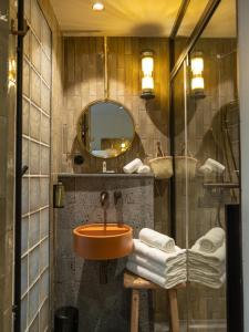 y baño con lavabo, espejo y toallas. en Hôtel le Tuit-Tuit, en La Plaine-des-Palmistes
