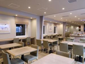 a restaurant with tables and chairs and a counter at Dormy Inn Gifu Ekimae in Gifu