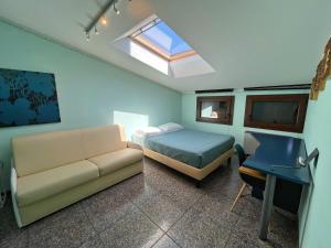 a bedroom with a bed and a couch and a desk at Appartamento Marchesini in Grado