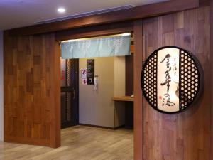 a room with a door with a sign on it at Dormy Inn Gifu Ekimae in Gifu