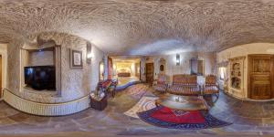 a large living room with a tv and a living room with chairs at Miras Hotel in Göreme