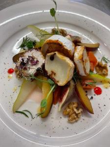 a white plate of food with vegetables on it at Panoramahotel Steirerland in Kitzeck im Sausal