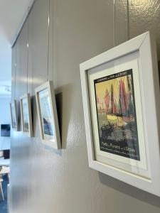 a row of framed pictures hanging on a wall at L'amarrage éphémère in La Rochelle