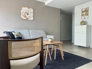 a living room with a table and a couch at L'amarrage éphémère in La Rochelle