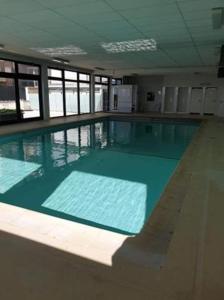 una gran piscina de agua azul en un edificio en Appartement voor gezin en Middelkerke