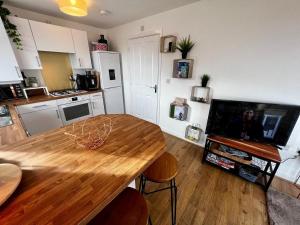 een woonkamer met een houten tafel en een keuken bij Two bedroom apartment in Barry-close to beach in Barry