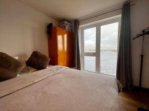 a bedroom with a bed and a large window at Two bedroom apartment in Barry-close to beach in Barry