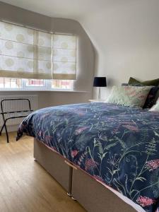 Un dormitorio con una cama con una manta azul y una ventana. en Home by the Sea in Rustington, en Rustington