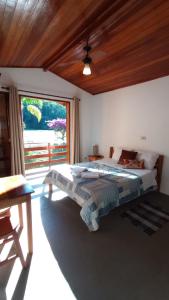 um quarto com uma cama e uma grande janela em Pousada Vitória em Gonçalves