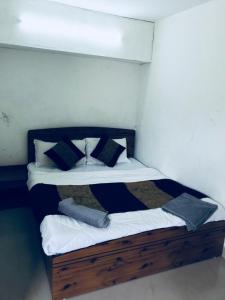 um quarto com uma cama com lençóis brancos e almofadas em Tarun Residency em Saharanpur