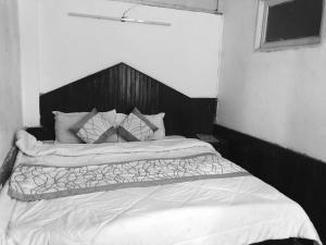 uma fotografia a preto e branco de uma cama num quarto em Tarun Residency em Saharanpur