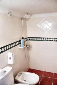 uma casa de banho com um WC branco e um lavatório. em One bedroom house with enclosed garden at Souto da Casa em Souto da Casa