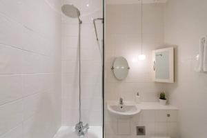 a white bathroom with a shower and a sink at The William Wallace, by the Design Traveller in London