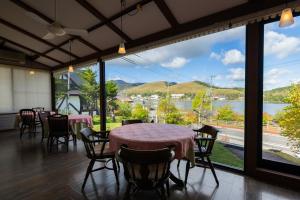 a room with tables and chairs and a large window at Little Grebe in Chino