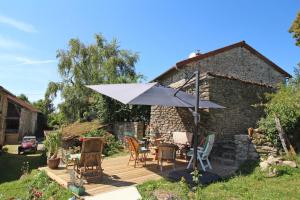 een patio met een tafel en een parasol bij Kernad in Bersac-sur-Rivalier